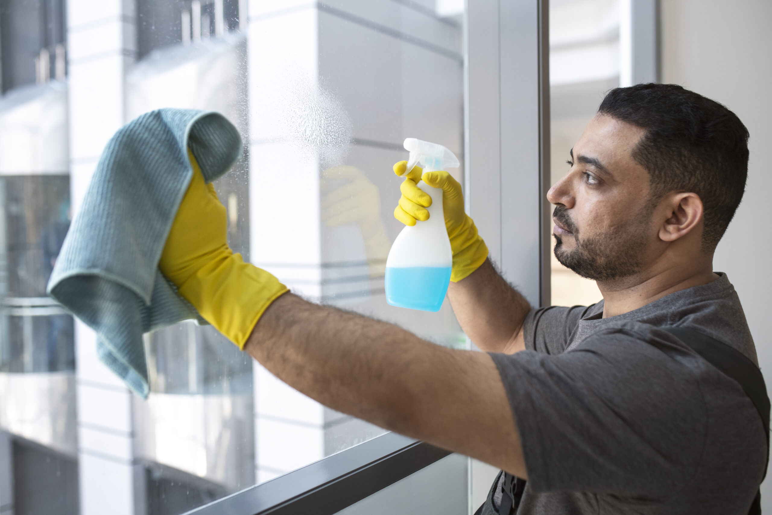 medium shot man cleaning office window scaled